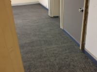 Old office carpeting before commercial vinyl installation, worn and stained